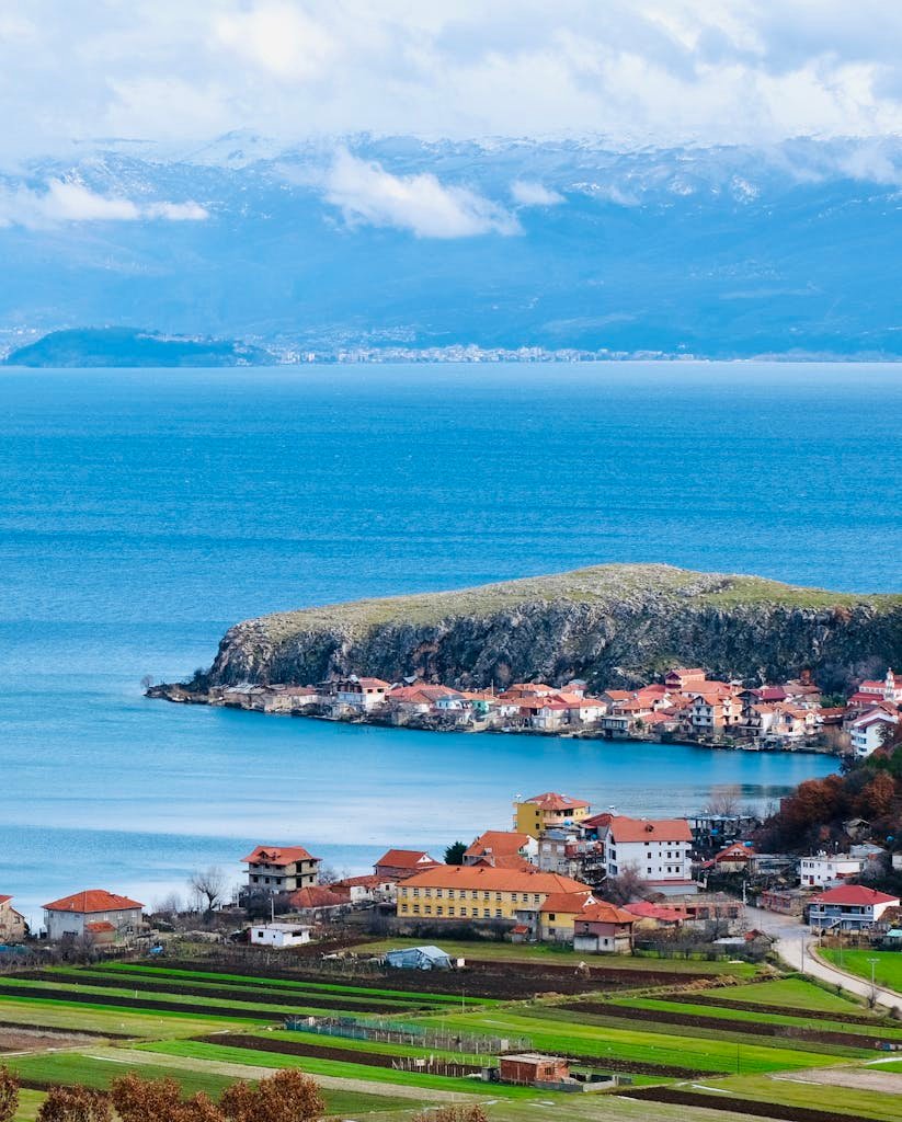 Aerial view of the picturesque village of Lin by Ohrid Lake in Albania, showcasing vibrant roofs.